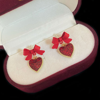 Aretes de corazón con lazo rojo