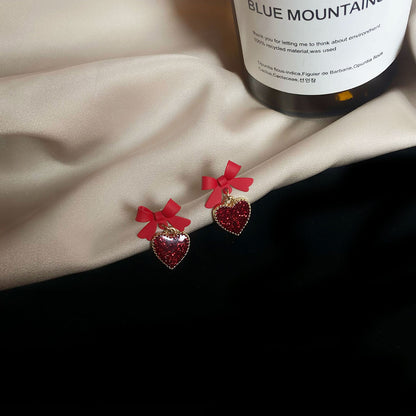 Aretes de corazón con lazo rojo