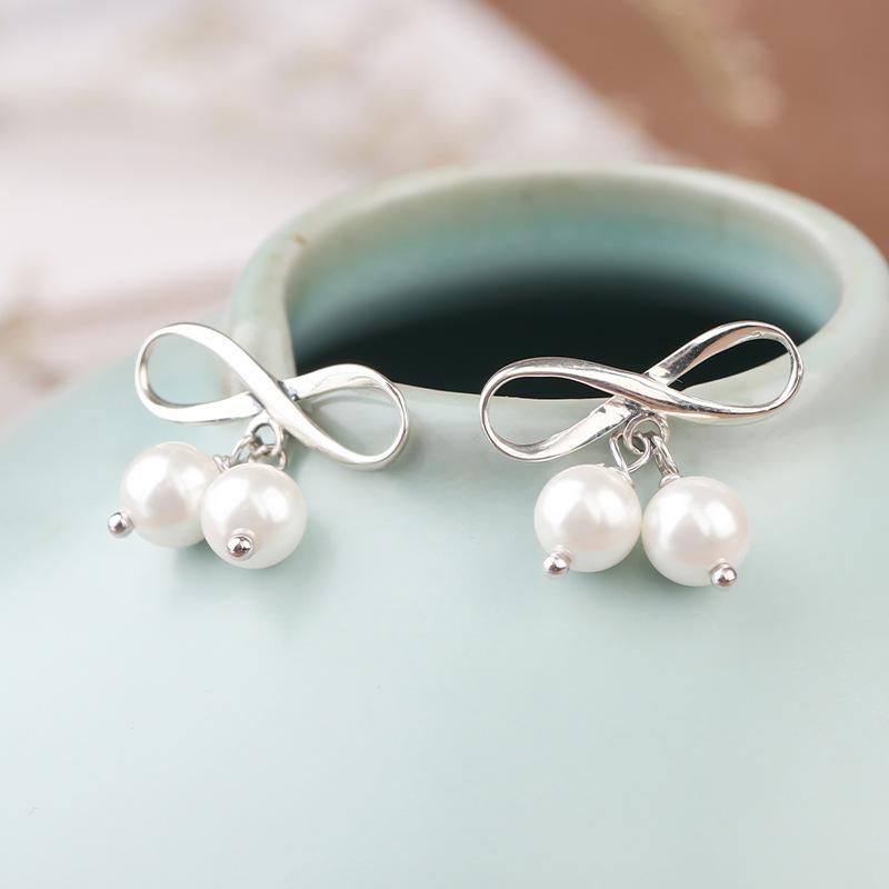 Preciosos pendientes de perlas de plata con lazo